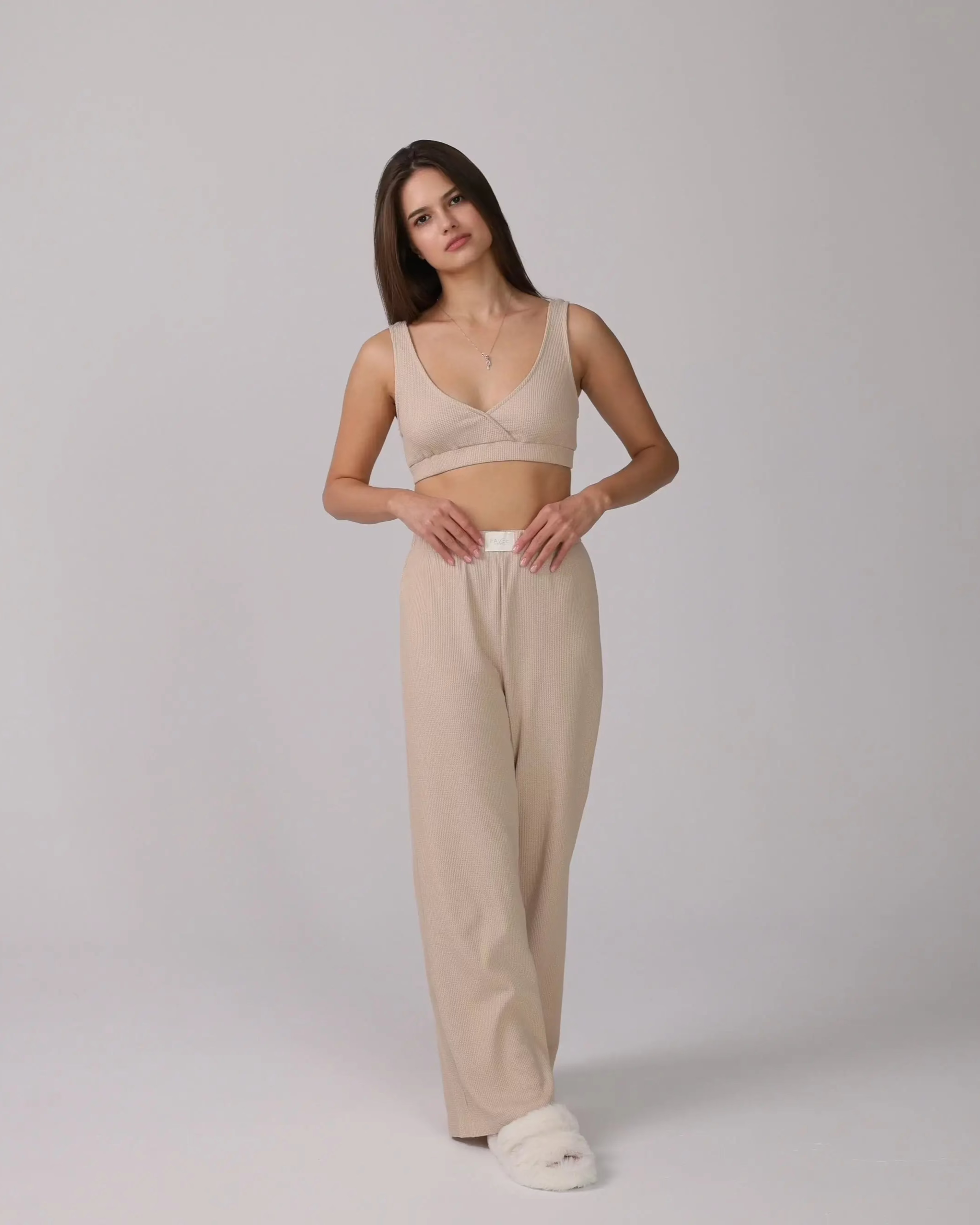 1. Woman wearing a beige 3-piece loungewear set with cardigan, top, and pants.
 2. Close-up of soft cotton fabric in the loungewear set.
 3. Loungewear set displayed neatly with shorts option on a minimalist background.
 4. Woman sitting on a sofa, relaxing in the cotton loungewear.